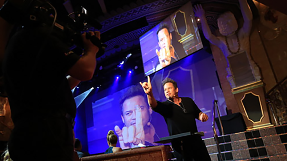 Bobby Borgia performs magic projected on screens aboard Carnival Cruise